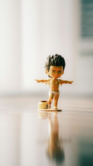 Golden Chibi Anime Character Figure Balancing on Honey Jar Wallpaper