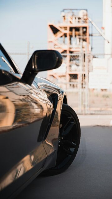 Sleek Black Sports Car Fender and Wheel Industrial Aesthetic Wallpaper