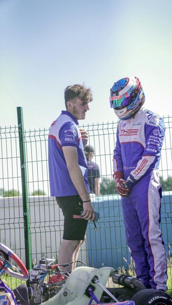Professional Kart Racing Driver Debriefing with Mechanic Mobile Wallpaper