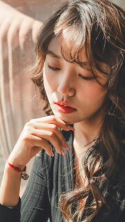 Stunning Portrait of a Pensive Young Woman with Sun-Kissed Hair Wallpaper