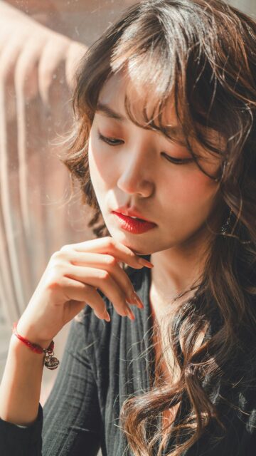 Stunning Portrait of a Pensive Young Woman with Sun-Kissed Hair Wallpaper