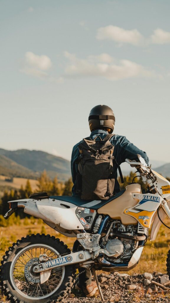 Adventurous Biker on Yamaha Dirt Bike Overlooking Mountains Wallpaper