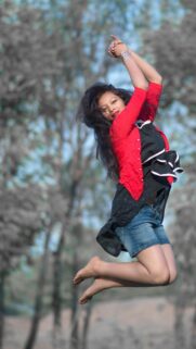 Joyful Girl Jumping in Nature Portrait Mobile Phone Wallpaper
