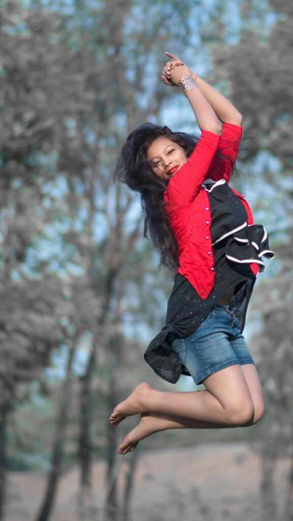 Joyful Girl Jumping in Nature Portrait Mobile Phone Wallpaper