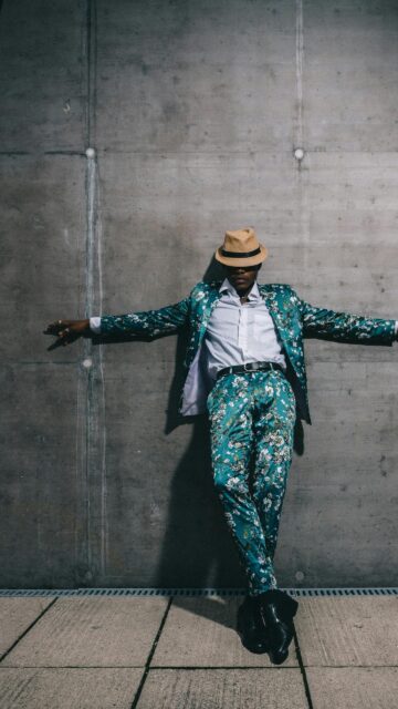 Stylish Man in Floral Suit and Fedora Hat Mobile Wallpaper