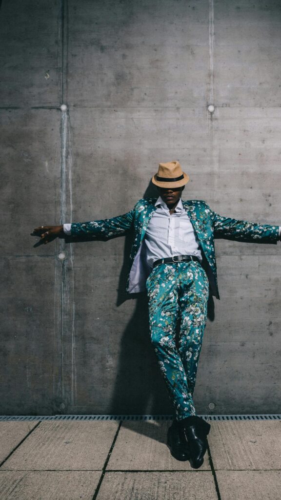 Stylish Man in Floral Suit and Fedora Hat Mobile Wallpaper