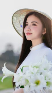 Beautiful Vietnamese Girl in Traditional Ao Dai with Lily Flowers Wallpaper