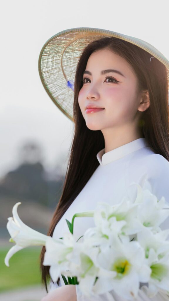 Beautiful Vietnamese Girl in Traditional Ao Dai with Lily Flowers Wallpaper