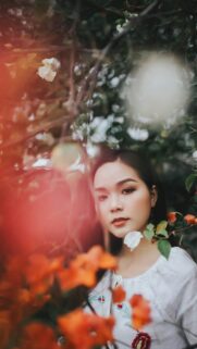 Portrait of a Beautiful Woman Among Orange Flowers Phone Wallpaper