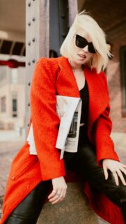 Edgy Blonde Woman in Vibrant Red Coat Street Style Phone Wallpaper