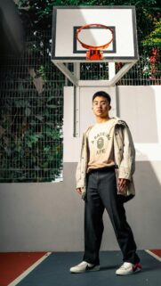 Stylish Young Man in Urban Streetwear Basketball Court Wallpaper