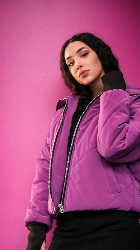 Stylish Young Woman in Purple Puffer Jacket Portrait Wallpaper