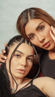 Elegant Duo Portrait with Braided Hairstyles Mobile Wallpaper