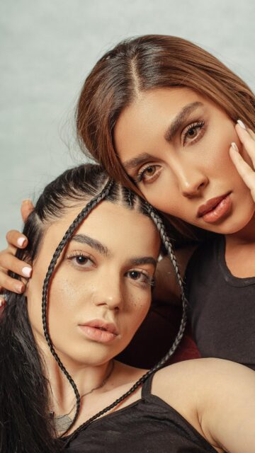 Elegant Duo Portrait with Braided Hairstyles Mobile Wallpaper