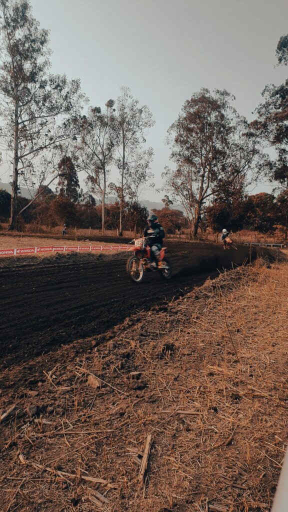 Thrilling Motocross Race on Dirt Track Mobile Wallpaper