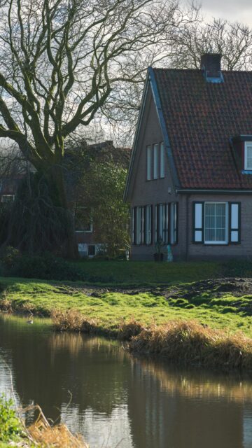 Scenic Brick House by a Peaceful Canal Phone Wallpaper