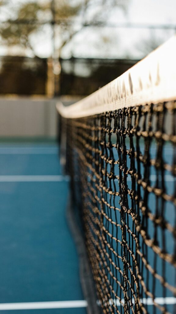 Macro Tennis Net Close-Up on Blue Court Mobile Wallpaper