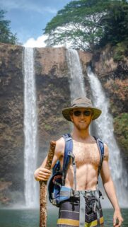 Adventurous Hiker at Tropical Waterfall Scenic Phone Wallpaper
