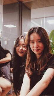 Portrait of Two Asian Friends Smiling in an Office Setting Wallpaper