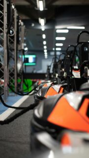 Orange and Black Electric Go-Karts in Racing Pit Lane Mobile Wallpaper