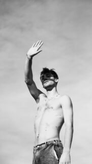 Shirtless Young Man Posing Against Sky Minimalist Black and White Wallpaper
