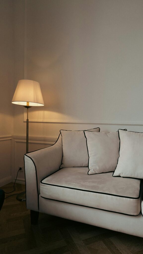 Elegant Minimalist Cream Sofa and Warm Ambient Floor Lamp Wallpaper