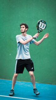Young Male Padel Player on Green Court Action Mobile Wallpaper