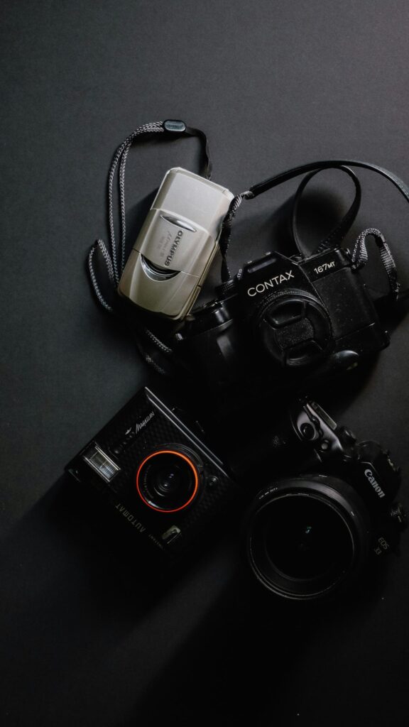 Retro Film Cameras Flat Lay on Dark Minimalist Surface Wallpaper