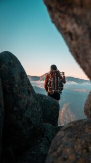 Hiker Exploring Mountain Peaks at Sunrise Mobile Wallpaper