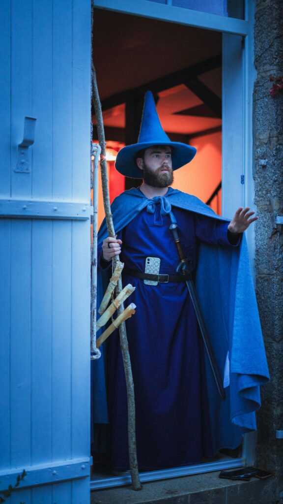 Fantasy Wizard in Blue Robes Standing at a Glowing Threshold Mobile Wallpaper