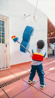 Joyful Child Hitting Piñata at Birthday Celebration Mobile Wallpaper
