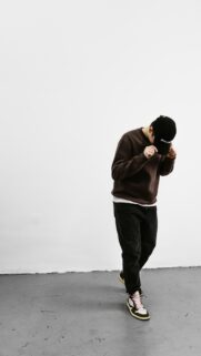 Stylish Man in Brown Sweatshirt and Sneakers Phone Wallpaper
