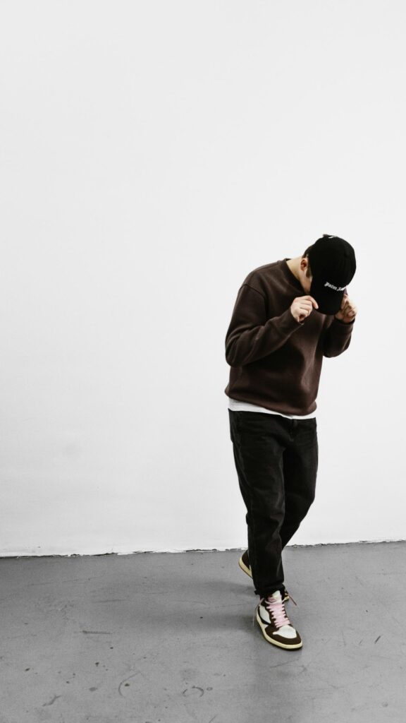 Stylish Man in Brown Sweatshirt and Sneakers Phone Wallpaper