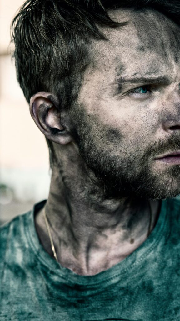 Gritty Survivor Portrait with Intense Blue Eyes Mobile Wallpaper