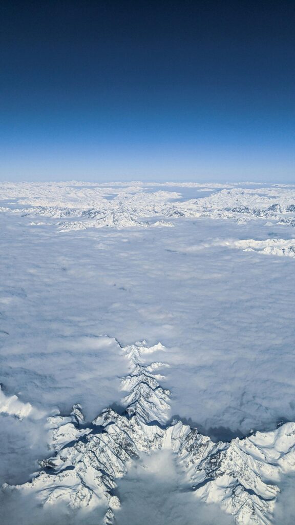 Stunning Snowy Mountain Range Above Clouds Aerial View Mobile Wallpaper