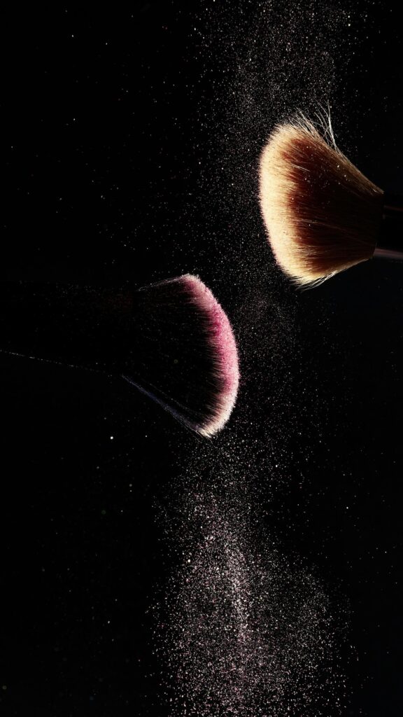 Elegant Makeup Brushes with Sparkling Pink Powder Mobile Wallpaper