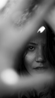 Stunning Black and White Portrait of a Woman Looking Through Fingers Wallpaper