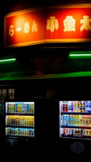 Neon Lit Japanese Ramen Shop with Vending Machines Phone Wallpaper