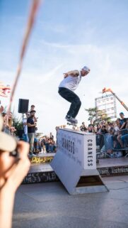 Professional Skater Performing Mid-Air Trick at Urban Competition Wallpaper