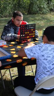 Two Friends Playing Connect Four Outdoors Lifestyle Mobile Wallpaper