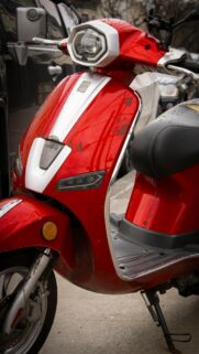 Vibrant Red Electric Scooter City Street Detail Mobile Wallpaper