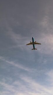 Stunning ITA Airways Blue Jet Airplane Soaring in Cloudy Sky Wallpaper