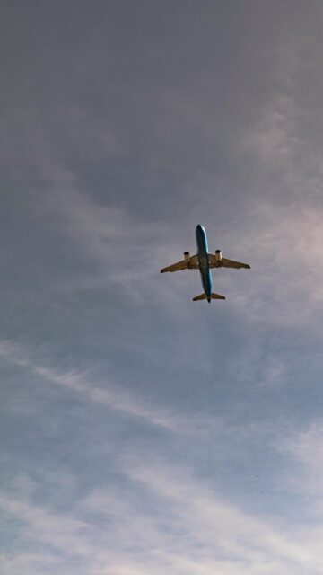 Stunning ITA Airways Blue Jet Airplane Soaring in Cloudy Sky Wallpaper