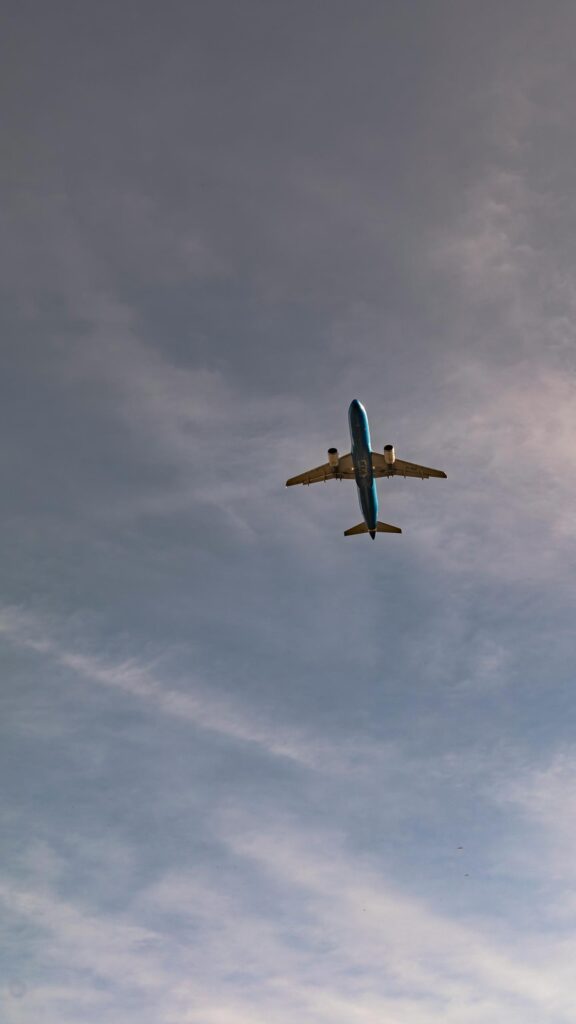 Stunning ITA Airways Blue Jet Airplane Soaring in Cloudy Sky Wallpaper