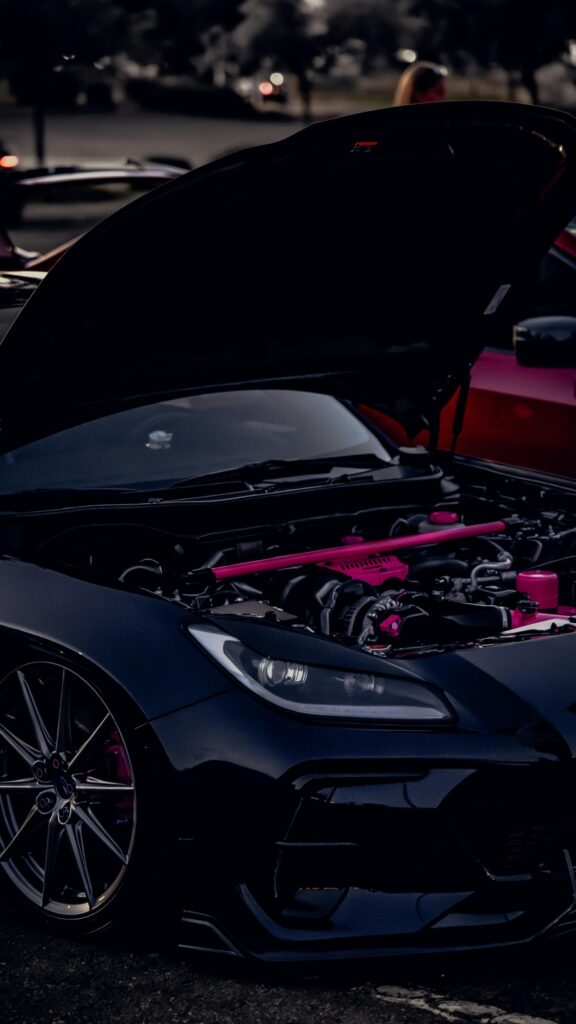 Custom Black Sports Car with Pink Engine Details Mobile Wallpaper