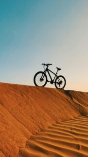 Silhouette Mountain Bike on Golden Desert Sand Dunes Mobile Wallpaper