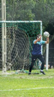 Professional Goalkeeper Making a Save in Soccer Match Mobile Wallpaper