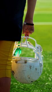 American Football Player Holding Helmet and Mouthguard Mobile Wallpaper