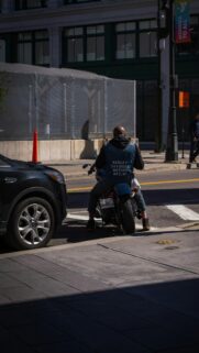 Biker Riding Harley Davidson Through City Streets Mobile Wallpaper