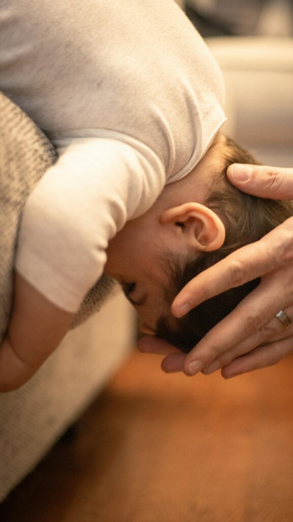 Tender Hands Holding A Sleeping Baby Head Close-Up Phone Wallpaper